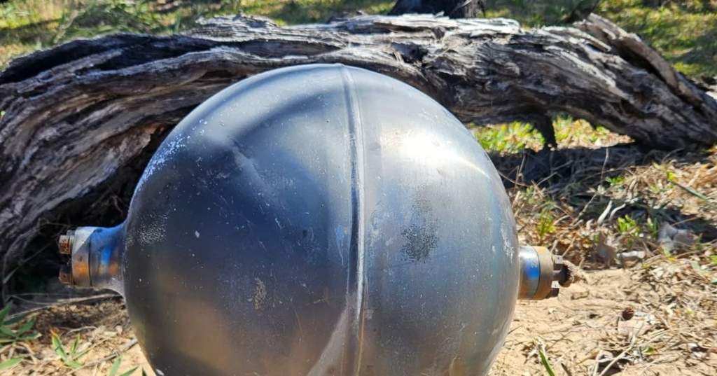 Bola logam misterius terdampar di pasir pantai utara Australia di bawah langit kelabu