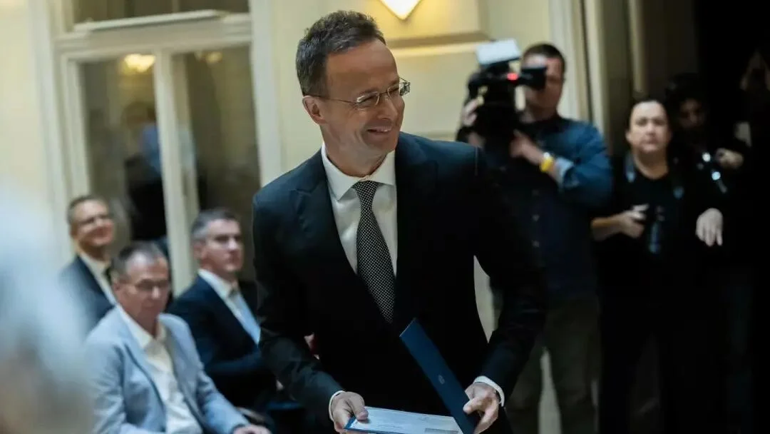 Péter Szijjártó posing for an official announcement picture regarding his corporate appointment.