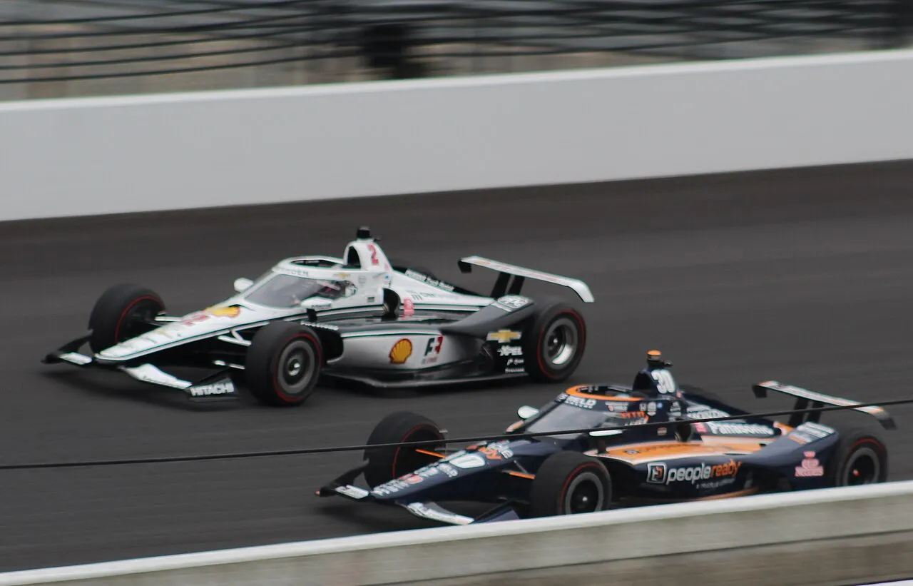 Dallara DW12 race car accelerating on track during IndyCar Series event