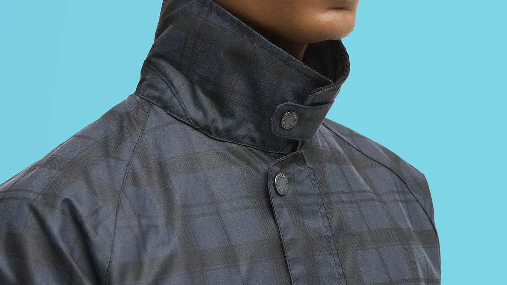 Pria mengenakan Barbour Tartan Ambleside Wax Jacket berwarna abu-abu biru dengan kerah hitam