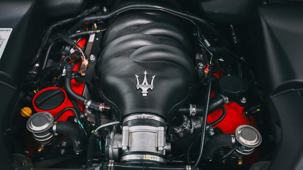 Mobil sport Maserati GranTurismo berbalut warna merah melaju di jalan raya.