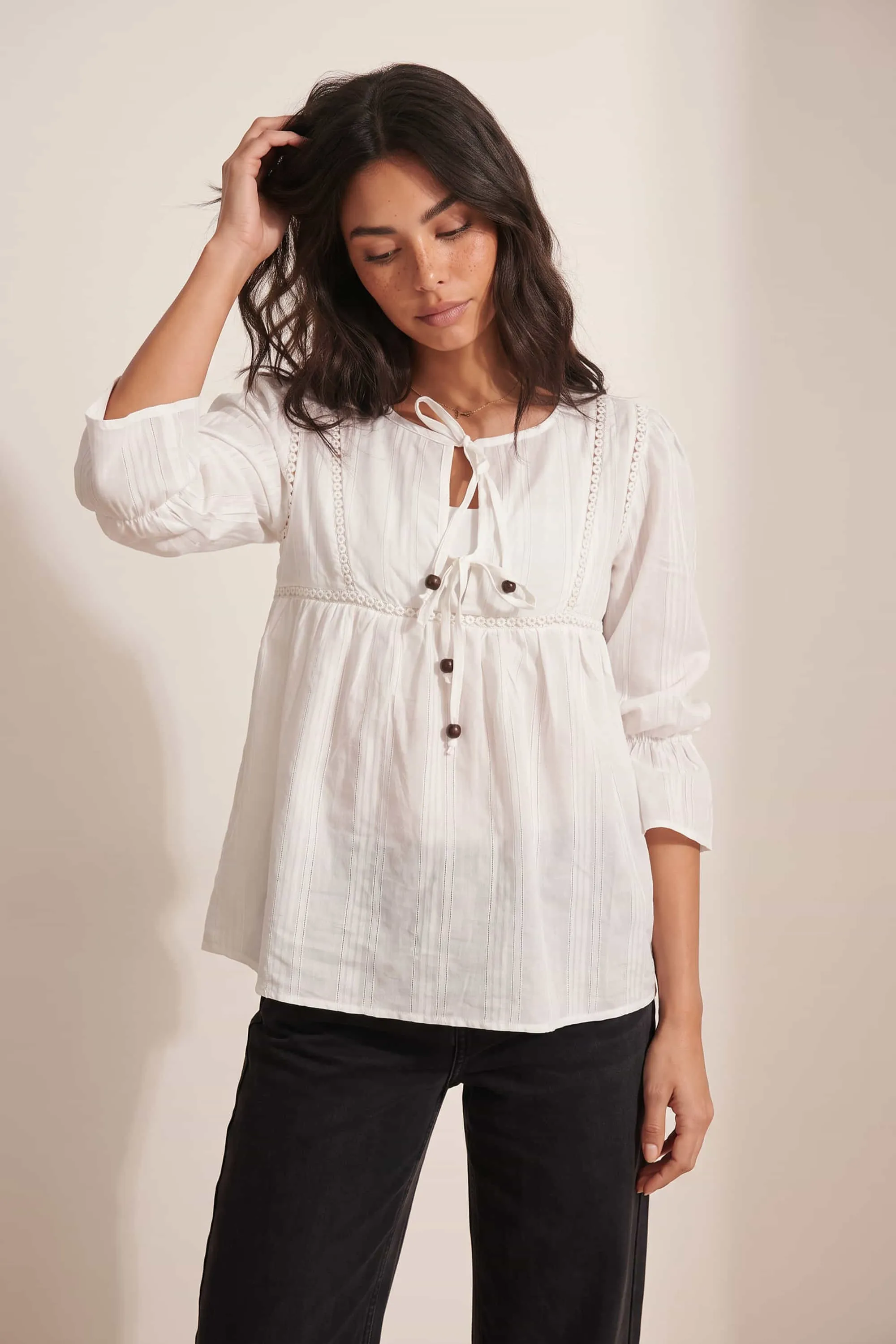 Tiered White Tie Textured Blouse Joy368 berwarna putih cream dengan detail renda